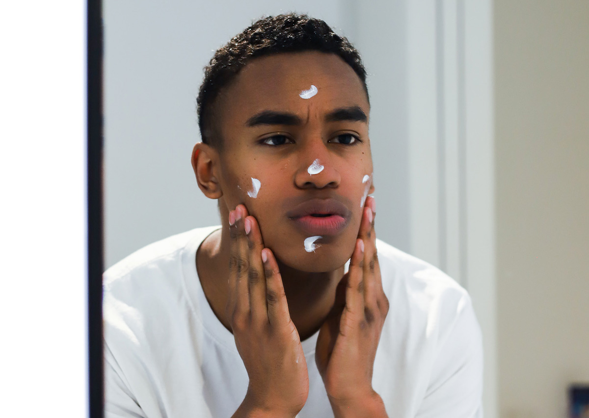 man moisturizing his face